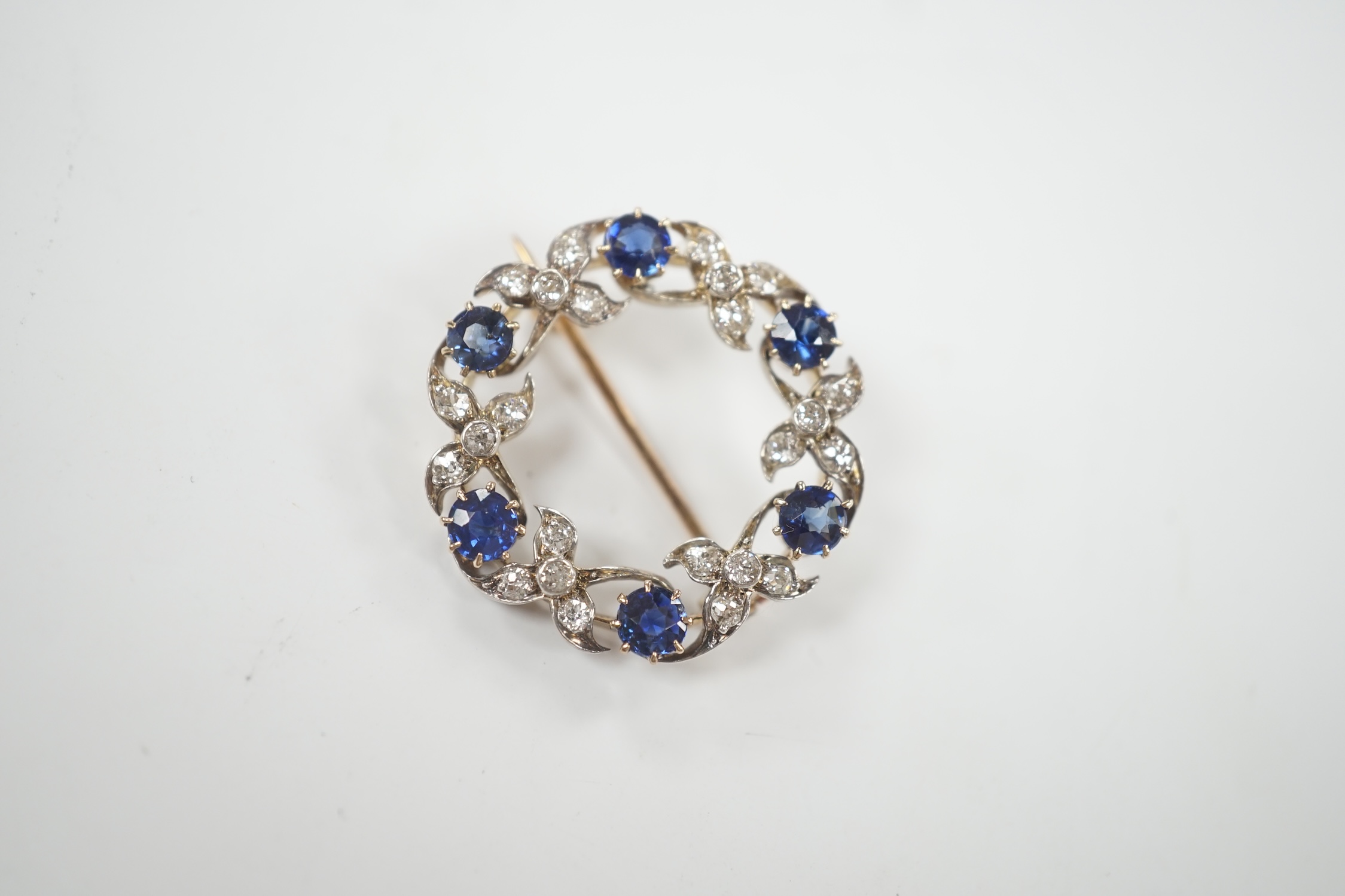 A yellow and white metal, sapphire and diamond cluster set openwork brooch, 24mm, gross weight 4.6 grams.